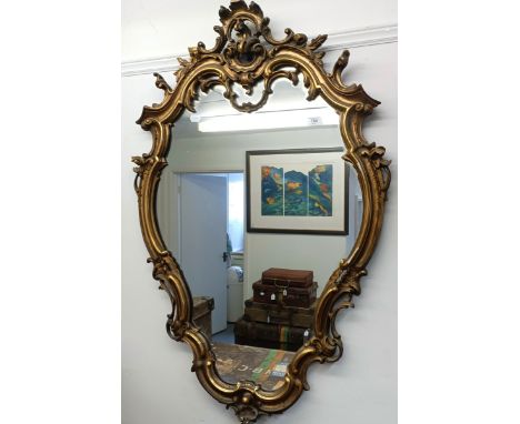 A carved giltwood wall mirror, of shaped cartouche form, 110 x 72 cmslight loss