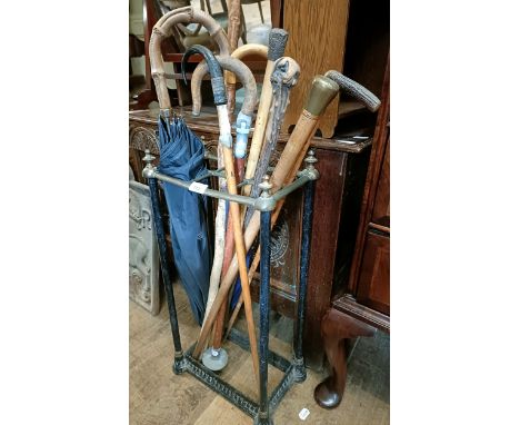 A brass and metal stick stand, 32 cm wide and assorted walking sticks (qty)