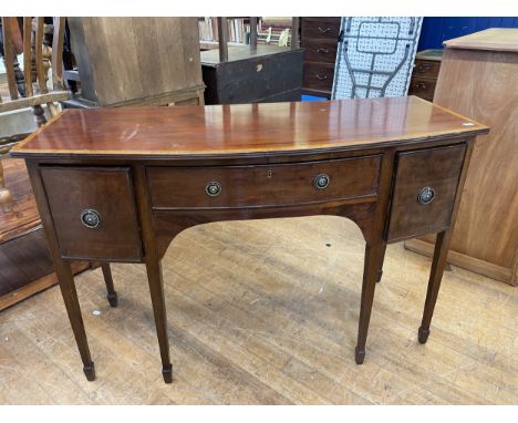 A mahogany bow front sideboard, having a central drawer flanked by a deep drawer and a cupboard door, 130 cm wide