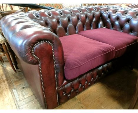 A red leather Chesterfield type two seater sofa, 160 cm wide
