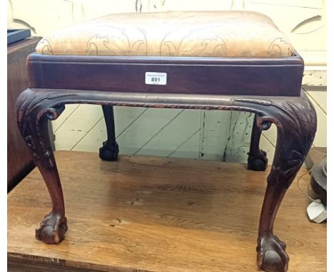 A mahogany stool, on carved legs with ball and claw feet, 54 cm wide