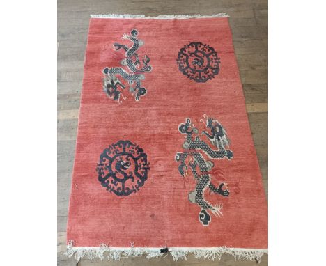 A Chinese red ground carpet, 305 cm x 198 cm