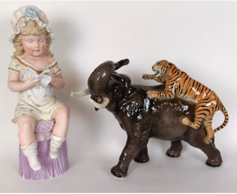 A bisque figure of a girl reading a book, 45 cm high, and a Beswick figure of an elephant being attacked by a tiger, tusks da