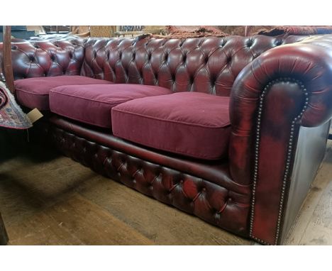 A red leather Chesterfield type three seater sofa, 205 cm wide