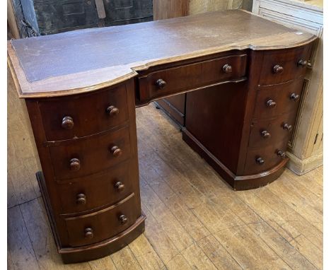 A mahogany kneehole desk, with a nine drawer configuration, 122 cm wide