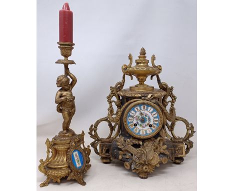 A French mantel clock, with a painted porcelain dial, in a gilt metal case, with a single matching candlestick, 34 cm high (2
