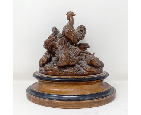 A James Morris Willcox of Bath wooden carving of a cockerel, chicken and chicks on an oval base, stamped Willcox Bath, 22 cm 