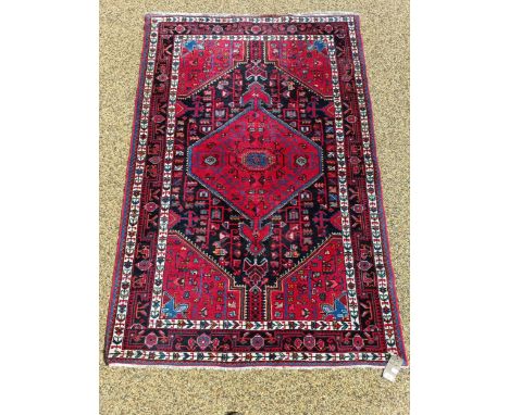 A Persian red ground rug, 218 cm x 143 cm