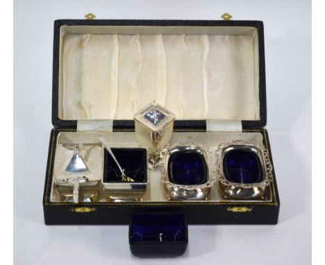 A silver three-piece condiment set with blue glass liners, Deakin & Francis, Birmingham 1919/22 (including a spare liner), to