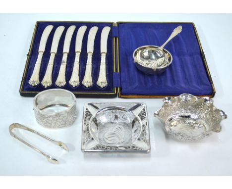 A silver tea strainer on stand, Birmingham 1950/51, to/w a pair of sugar tongs, a Victorian engraved broad hinged bangle, Bir