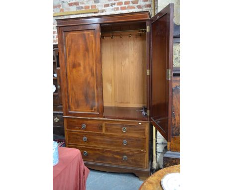 An early 20th century crossbanded mahogany linen press having a pair of panelled doors enclosing a hanging rail and multiple 