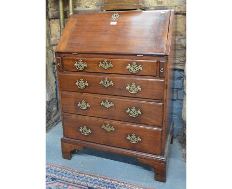 A small George III mahogany bureau, the hinged fall enclosing a fitted interior over four long graduated drawers with brass f