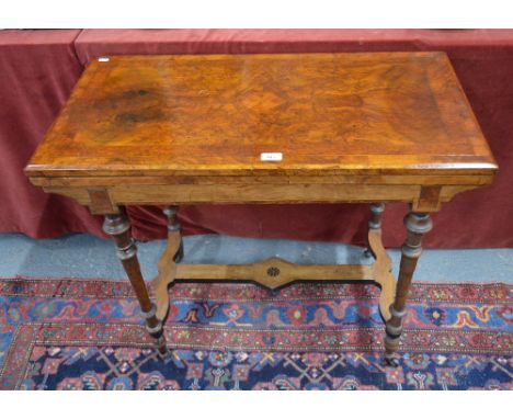 A late 19th century yew crossbanded walnut card table, the rectangular revolving fold over top enclosing a baize lined surfac
