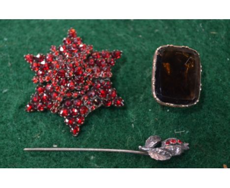 A garnet set star brooch to/w a smoky quartz foil backed brooch   Condition Report  Bruised, repaired and stick pin damaged