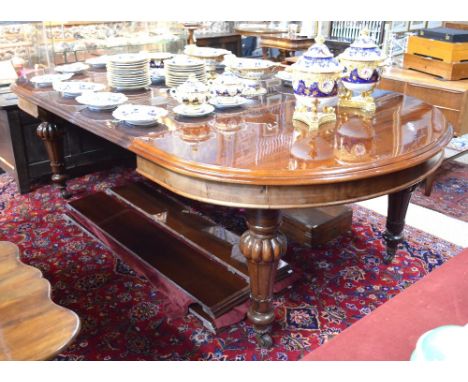 A large Victorian mahogany extending dining table having demi-lune ends and with two wide, one medium and two narrow leaf ins