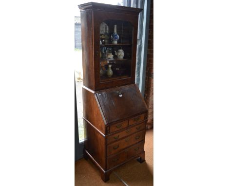 An 18th century and later walnut bureau bookcase, the glazed cabinet door enclosing a later mirror panelled back, adjustable 