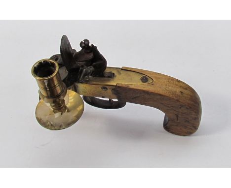 A table candlestick holder in the form of a flintlock pistol