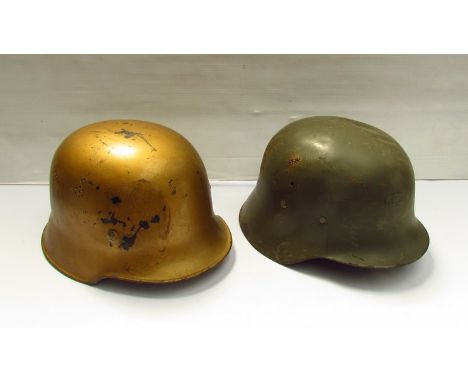 A German police helmet painted gold, part liner intact, together with another (2)  