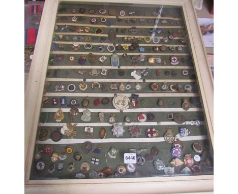A collection of military and civilian badges including British wound badge, Women's Land Army, ARP, NFS, Naval, etc in displa