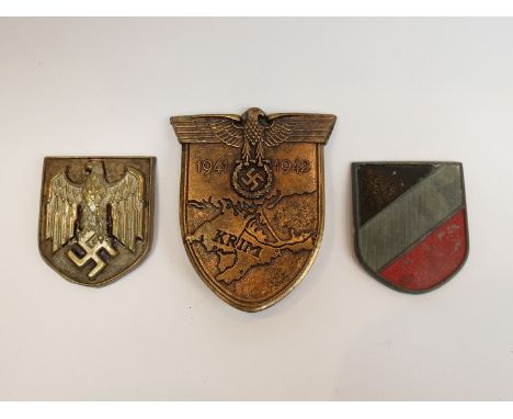 A German pattern Krim campaign badge and two helmet shield badges (3) 