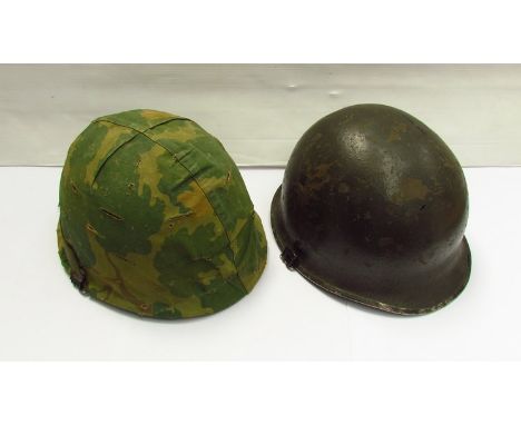 A US Army front seamed helmet together with a later example with camouflage cover (2)  