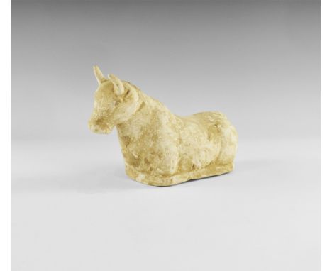 An undated archaistic ceramic figurine of a bull with legs folded beneath the body; hollow to the underside. Acquired on the 