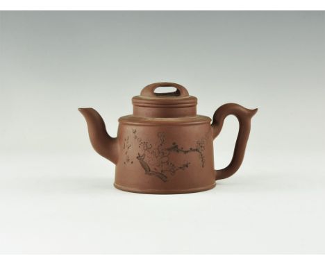 20th century AD. An unglazed ceramic redware teapot and lid with incised designs of lotus blossom and bamboo, columns of text