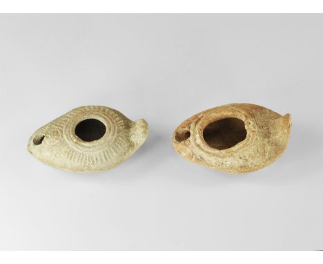 5th-8th century AD. A mixed pair of ceramic lamps each with domed shoulder and radiating strokes, fan-shaped lug handle. Prop