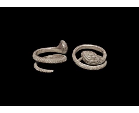 An undated archaistic silver D-section coiled band with scale detailing to the outer face, lozengiform snake-head finial. Pro