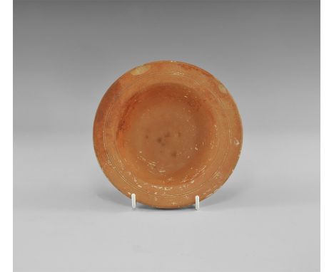 4th century AD. A red ware ceramic bowl with flange rim, two concentric incised lines; label to the bottom with printed text: