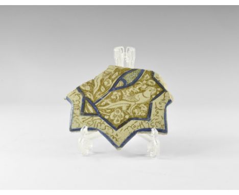 14th-15th century AD. A glazed ceramic tile fragment, shaped as an eight-pointed star with lustre overglaze; blue edges to th