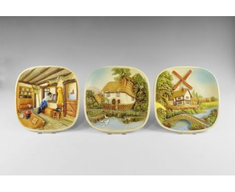 20th century AD. A group of three ceramic wall plaques with high-relief scenes comprising: a thatched cottage among trees; a 