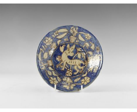 20th century AD. A ceramic bowl with basal ring, blue-glazed face with reserved advancing deer among flowers, rim with potted