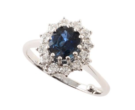 Sapphire and diamond 18ct white gold cluster ring , central oval mixed cut sapphire weighing approx 1.50 carats, claw set to 