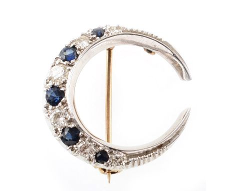 Sapphire and diamond white gold crescent-shaped brooch , comprising alternating mixed cut sapphires and brilliant cut diamond