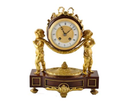 A late 19th century Scottish mahogany and gilded bronze mantle clock. A pair of bronze putti hold aloft the turned mahogany c