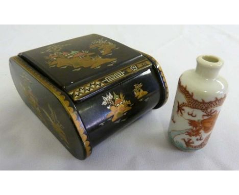 An Oriental papier mache box with hinged cover and a porcelain snuff bottle
