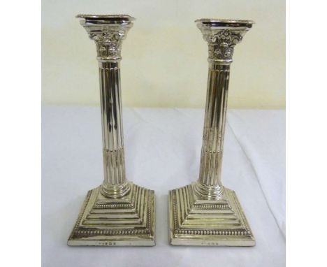 Pair of silver Corinthian column table candlesticks on stepped square bases with beaded borders, Birmingham 1929