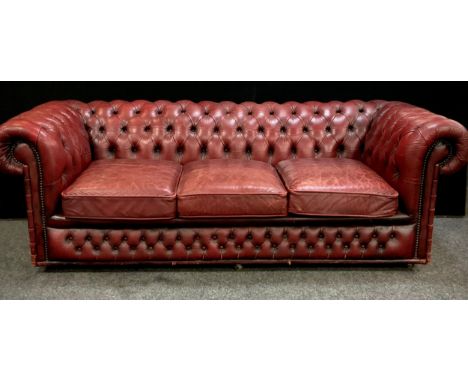 An Oxblood red leather chesterfield three seater sofa, 67cm high, 200cm wide, 90cm deep, seat height 40cm 