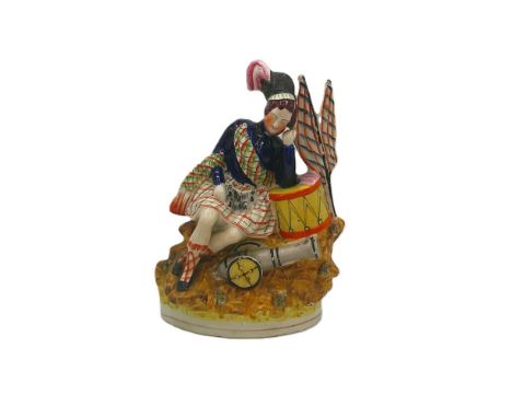 A Staffordshire portrait figure of a sleeping Scottish soldier, his head resting on his hand and arm on the drum, known as ‘S
