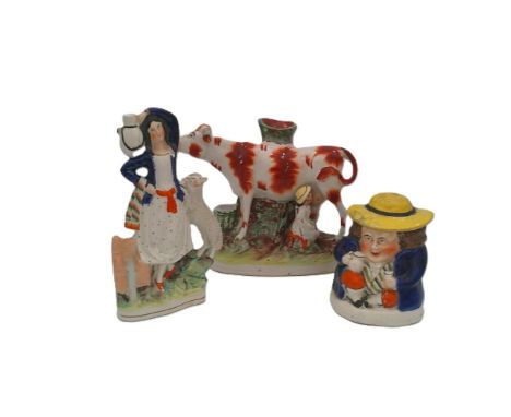 Three pieces of Staffordshire pottery, A girl and lamb, a cow and maid spill holder and a snuff box figure, Circa 19th centur
