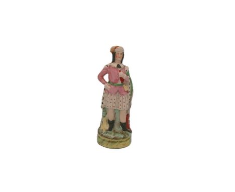 A Staffordshire portrait figure of a Hunter, holding a horn in his left hand, with a gun to his side and a game bird. Circa 1