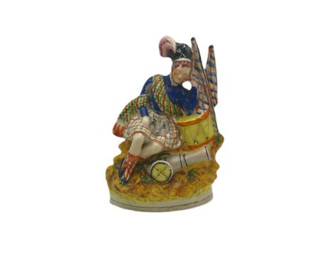 A Staffordshire portrait figure of a sleeping Scottish soldier, his head resting on his hand and arm on the drum, known as ‘S