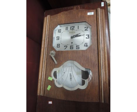 An Art Deco style oak cased wall clock having canted face, marked Suisse-Jve Jura with silver glass panel decoration