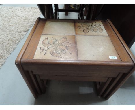 A vintage teak and tile nest of three tables
