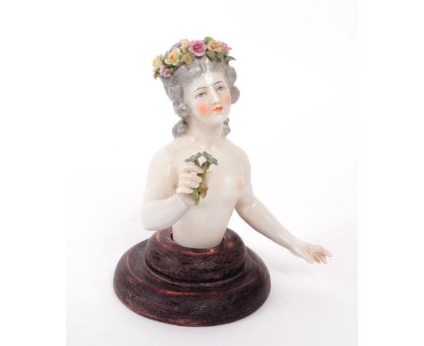 Dressel &amp; Kister - A 1910 Dresden German porcelain half doll figure, depicted holding flowers, mounted on a wooden stand.