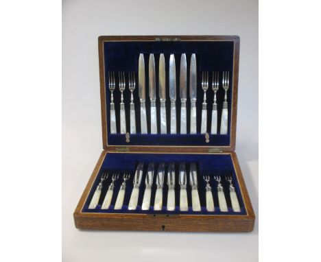 A cased set of 12 pairs of EPNS fruit eaters with mother of pearl handles and silver ferrules, a cased nut cracker and pick, 