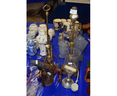 A vintage blow lamp together with two brass table lamps and a further glass goblet