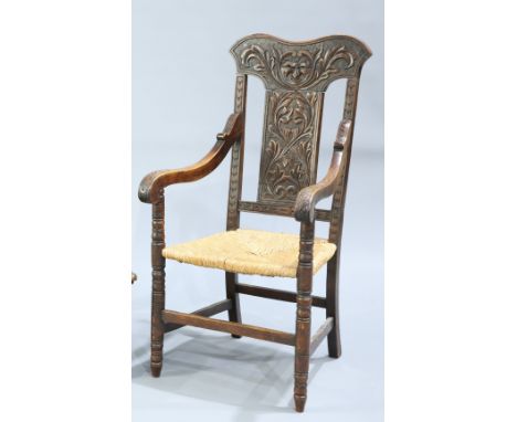 A LATE VICTORIAN CARVED OAK OPEN ARMCHAIR,&nbsp;the shaped crest carved with a mask and scrolling acanthus over a similarly c