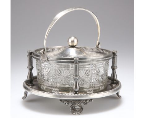 A LATE VICTORIAN SILVER-PLATED AND GLASS BUTTER DISH, by Walker &amp; Hall, circular with swing-handle and shell-form feet. 1